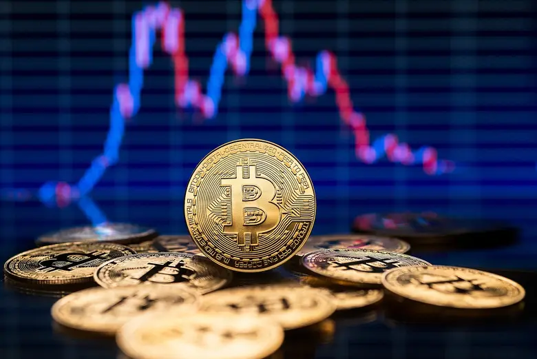 Ein Stapel Bitcoins vor einer Kursgrafik