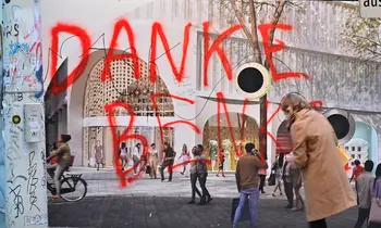 Rote Graffiti-Schrift Danke Benko an einer verhängten Fassade einer Baustelle, davor gehen Passanten vorbei.