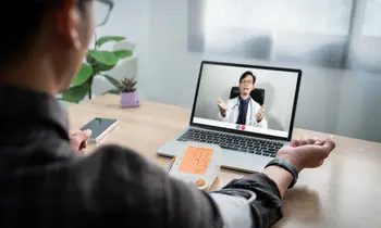 Patient misst Blutdruck während Videoarzttermin am Laptop