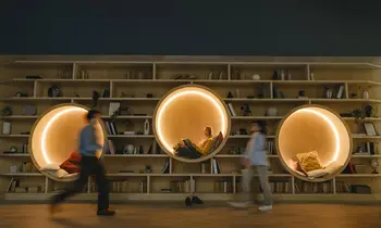 Das Foto zeigt drei Menschen vor einem großen Bücherregal.