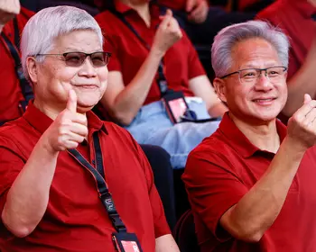Che-chia Wei, TSMC-Chef, und NVIDIA-Gründer Jensen Huang sitzen nebeneinander in roten Polohemden und lachen in die Kamera. Wei zeigt einen Daumen hoch, Huang ein Herzzeichen.