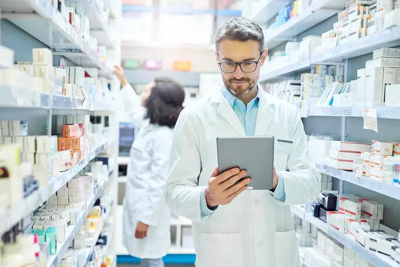 Apotheker prüft Medikamente auf Tablet – Symbolbild für den US-Healthcare-Sektor.
