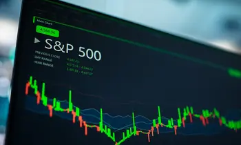 Computermonitor mit S&P-500-Kursanzeige, Candlestick-Chart in Grün und Rot sowie Kursdaten auf dunklem Hintergrund.