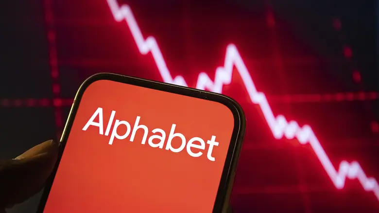 Alphabet Corporate Branding auf dem Smartphone Bildschirm vor rotem, sinkendem Börsendiagramm. 