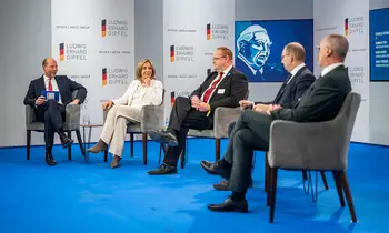 Fünf Personen sitzen bei einer Podiumsdiskussion auf einer Bühne.