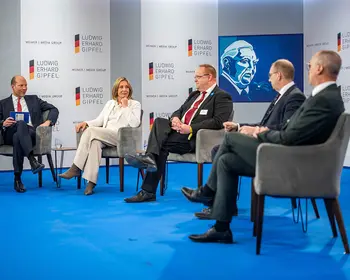 Fünf Personen sitzen bei einer Podiumsdiskussion auf einer Bühne.