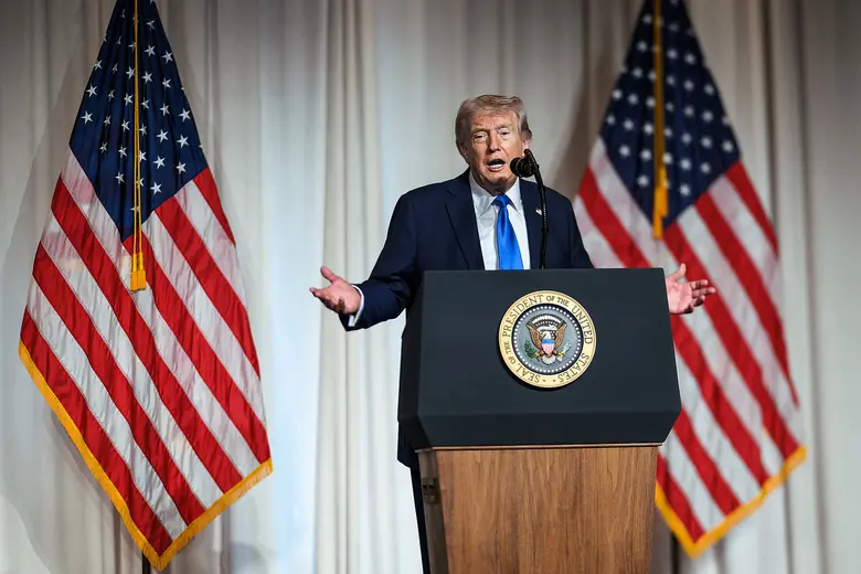 Donald Trump an einem Podium vor US-Flaggen.
