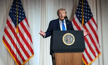 Donald Trump an einem Podium vor US-Flaggen.