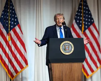 Donald Trump an einem Podium vor US-Flaggen.