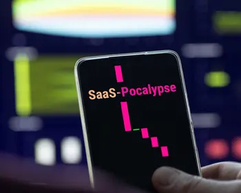 Eine Hand hält ein Smartphone, auf dessen dunklem Display der Begriff SaaSpocalypse und ein fallender pinker Kurschart zu sehen sind.