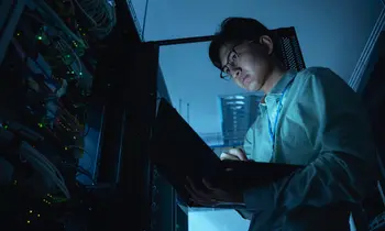 Ein Ingenieur kontrolliert Server in einem Rechenzentrum mit einem Tablet.