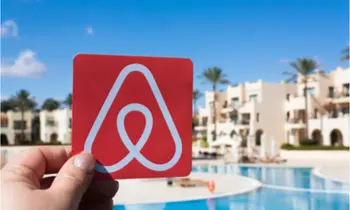 Blick auf Airbnb-Logo, Hotel und Pool. 