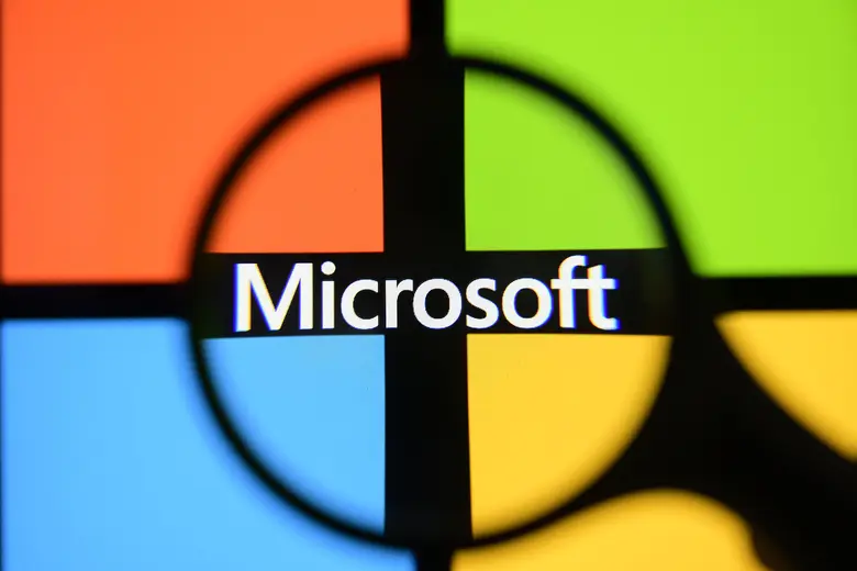 Das vierfarbige Microsoft-Logo auf einem Bildschirm, durch eine schwarze Lupe fotografiert.