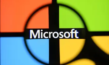 Das vierfarbige Microsoft-Logo auf einem Bildschirm, durch eine schwarze Lupe fotografiert.