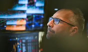 Ein Börsenhändler sitzt im Handelssaal der Frankfurter Wertpapierbörse vor seinen Monitoren. 