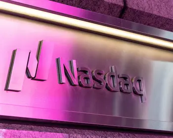 Metallschild mit dem Nasdaq-Logo und dem Schriftzug Nasdaq, das in Pink und Magenta beleuchtet wird.
