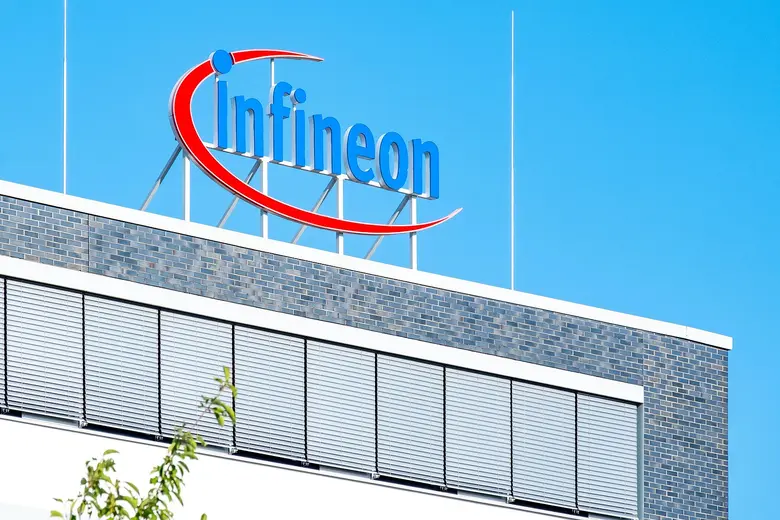 Infineon-Logo auf dem Dach eines Gebäudes vor blauem Himmel.