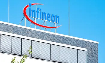 Infineon-Logo auf dem Dach eines Gebäudes vor blauem Himmel.