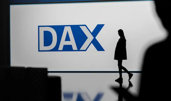 Großer blauer DAX-Schriftzug auf heller Fläche, rechts davon die Silhouette einer Person.