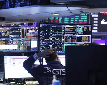 Börsenhändler vor Bildschirmen an der NYSE. 