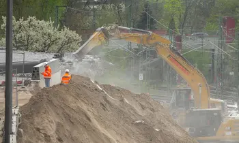 Bagger und Bauarbeiter auf einer Baustelle beim Abriss einer Brücke in Berlin.