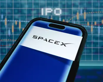 Smartphone mit dem SpaceX-Logo auf dem Display vor einem blauen Kursdiagramm mit dem Schriftzug IPO.