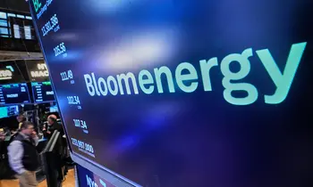 Bloom-Energy-Logo auf einem Börsenbildschirm über dem Parkett der New York Stock Exchange.