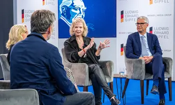 Podiumsdiskussion mit mehreren Personen auf einer Bühne beim Ludwig-Erhard-Gipfel.