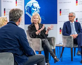 Podiumsdiskussion mit mehreren Personen auf einer Bühne beim Ludwig-Erhard-Gipfel.