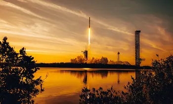 Raketenstart bei Sonnenuntergang über Wasser mit Rauchwolke