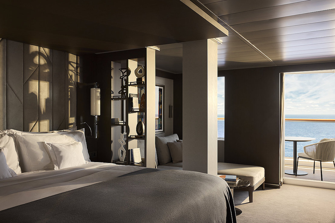 Das Bild zeigt ein Doppelbett auf einem Kreuzfahrtschiff mit Blick nach draußen.