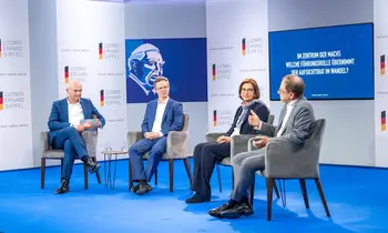 Vier Personen sitzen auf einer Bühne bei einer Podiumsdiskussion.