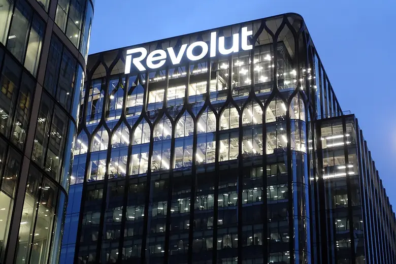 Beleuchtetes Revolut-Gebäude mit großem Schriftzug am Abend.